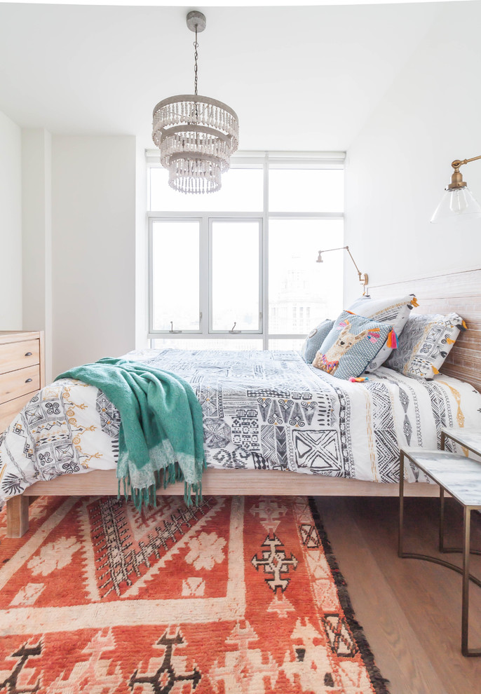 Inspiration pour une chambre d'amis traditionnelle de taille moyenne avec un mur blanc et un sol en bois brun.