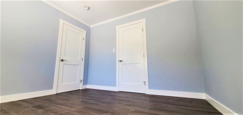 Ejemplo de habitación de invitados de estilo americano grande sin chimenea con paredes azules, suelo vinílico y suelo azul
