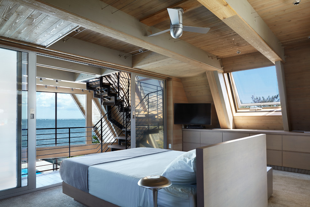 Ejemplo de dormitorio tipo loft y televisión contemporáneo de tamaño medio sin chimenea con paredes beige, moqueta, suelo beige y techo inclinado