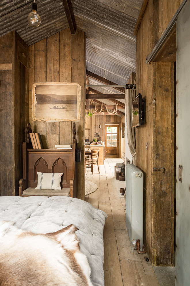 Inspiration for a rustic master bedroom in Cornwall with medium hardwood flooring.