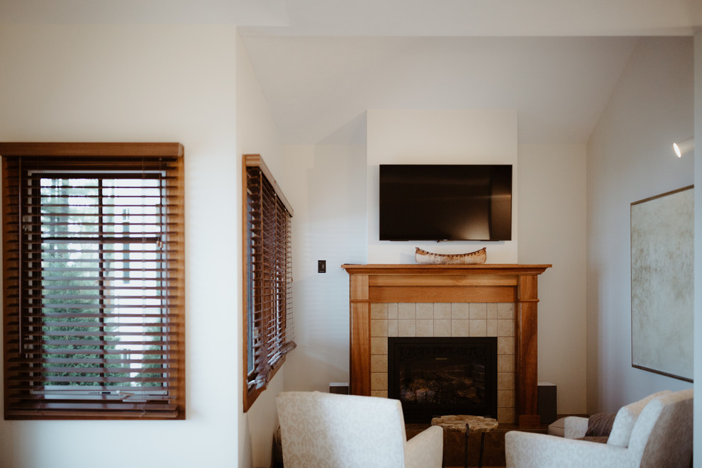 Réalisation d'une grande chambre parentale minimaliste avec un mur beige, une cheminée standard et un manteau de cheminée en carrelage.