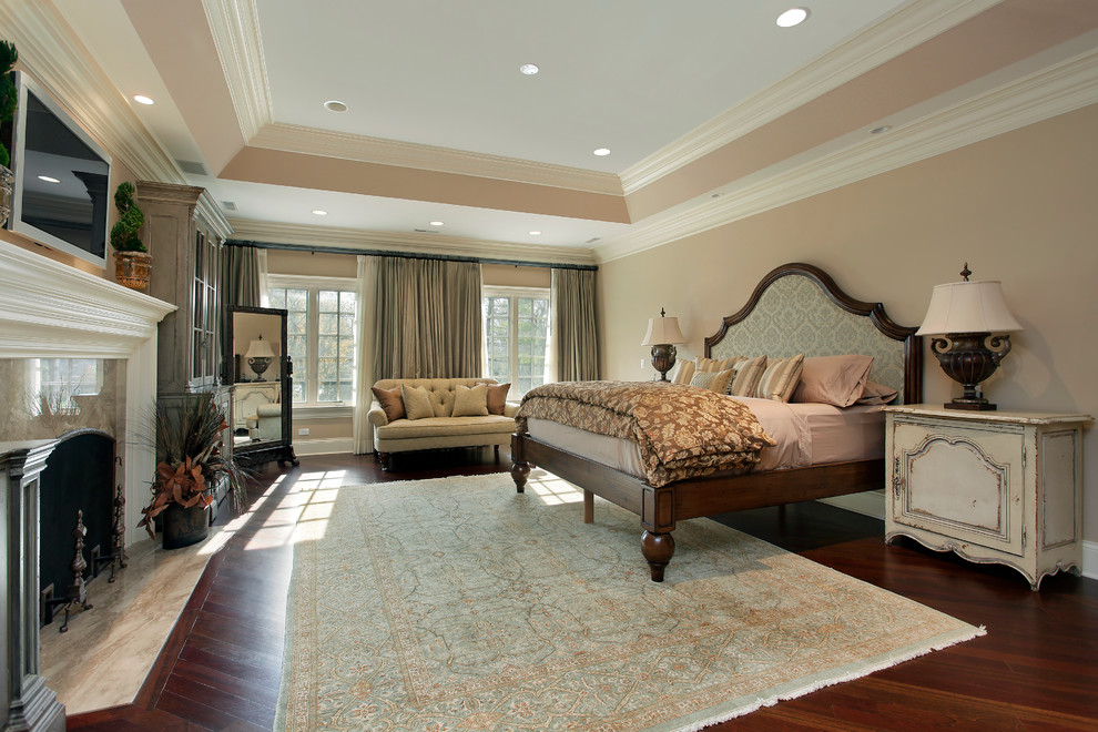 Klassisches Schlafzimmer mit brauner Wandfarbe, dunklem Holzboden und Kamin in Los Angeles