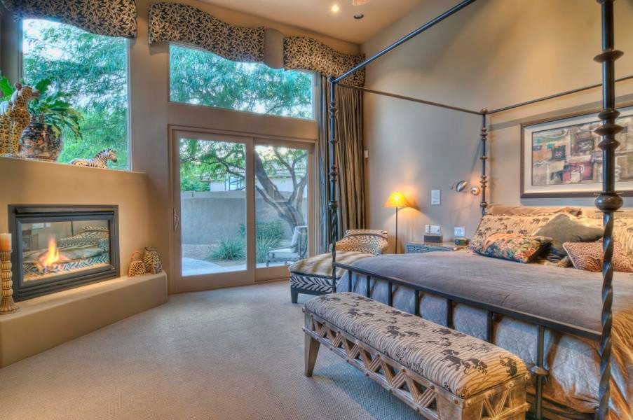 Design ideas for an expansive classic master bedroom in Phoenix with beige walls, carpet, a standard fireplace and a stone fireplace surround.