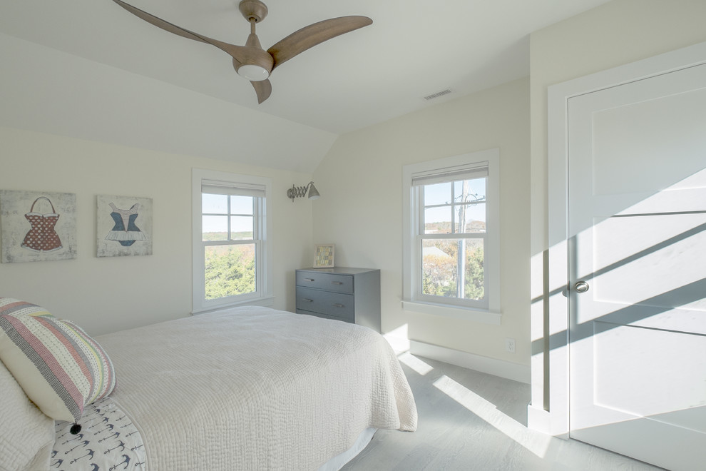 Foto di una camera degli ospiti costiera di medie dimensioni con pareti bianche, pavimento in legno massello medio e nessun camino