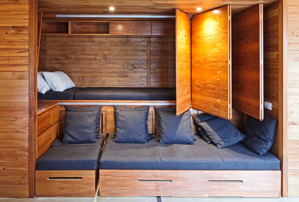 Foto på ett litet maritimt gästrum, med bruna väggar