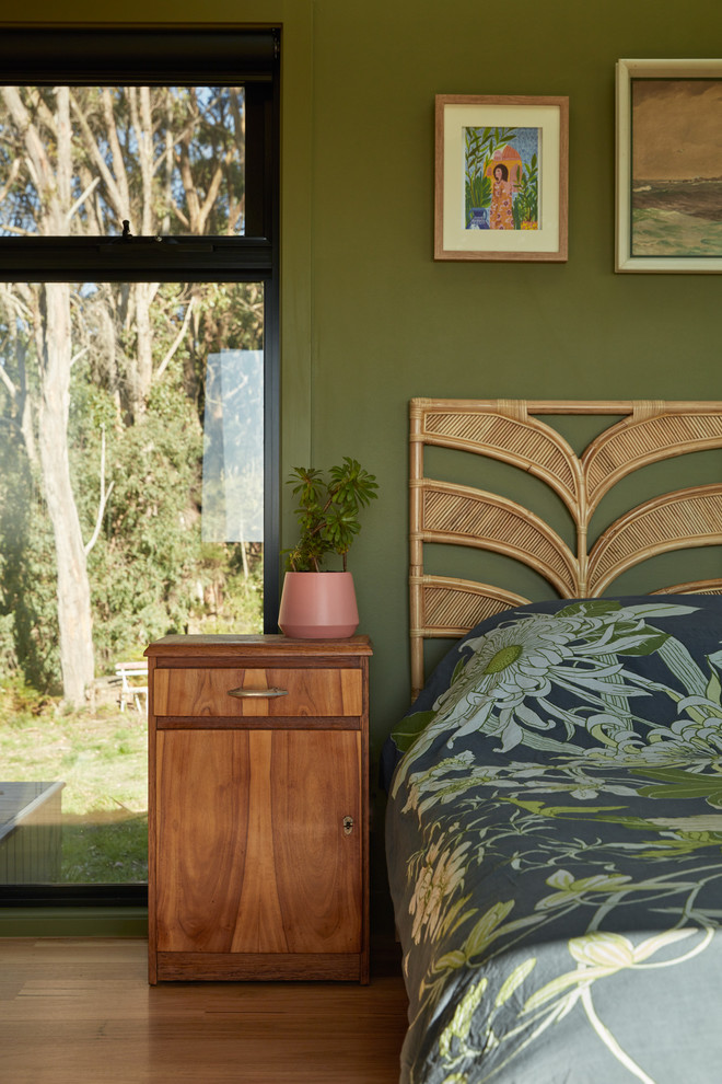 Modernes Schlafzimmer mit grüner Wandfarbe, braunem Holzboden und braunem Boden in Melbourne