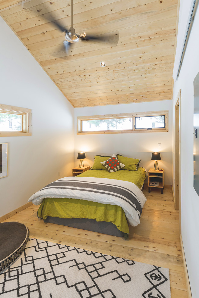 Diseño de dormitorio rústico con paredes blancas, suelo de madera clara y suelo beige