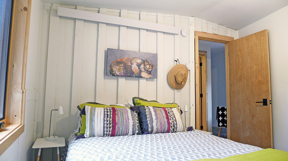 Mittelgroßes Uriges Gästezimmer mit weißer Wandfarbe, hellem Holzboden und beigem Boden in Sonstige