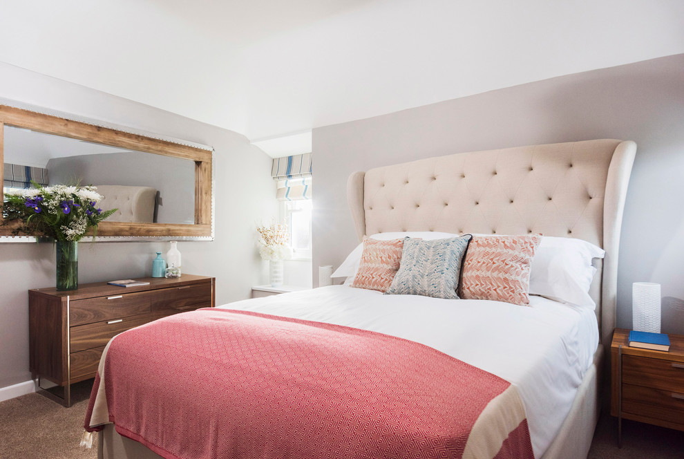 This is an example of a beach style master bedroom in Cornwall with grey walls.