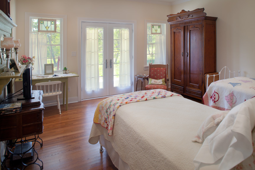 Diseño de habitación de invitados de estilo de casa de campo de tamaño medio sin chimenea con paredes beige y suelo de madera en tonos medios