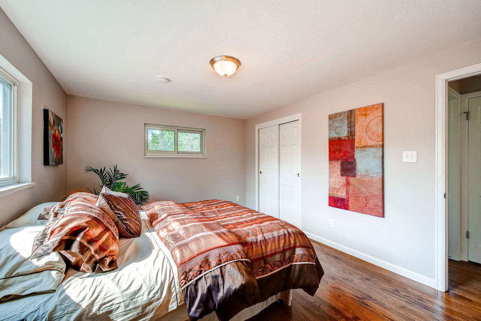 Idée de décoration pour une chambre d'amis minimaliste de taille moyenne avec un mur gris, un sol en bois brun et aucune cheminée.