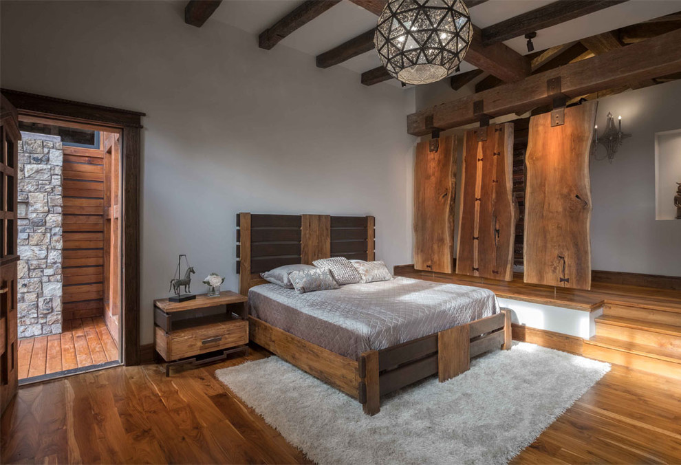 Large rustic master bedroom in Phoenix with white walls and medium hardwood flooring.