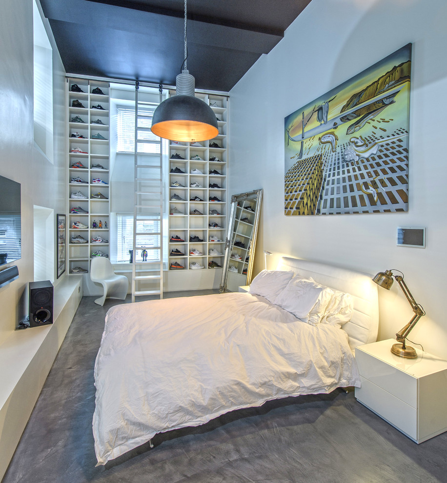 Foto di una camera da letto industriale di medie dimensioni con pareti bianche, pavimento in cemento e pavimento grigio