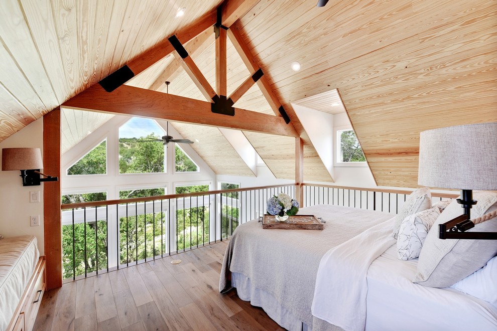 This is an example of a farmhouse mezzanine loft bedroom in Austin with light hardwood flooring and beige floors.