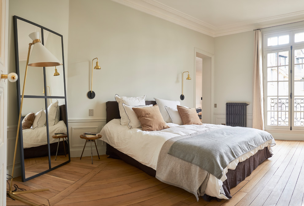 На фото: хозяйская спальня в скандинавском стиле с серыми стенами и светлым паркетным полом с