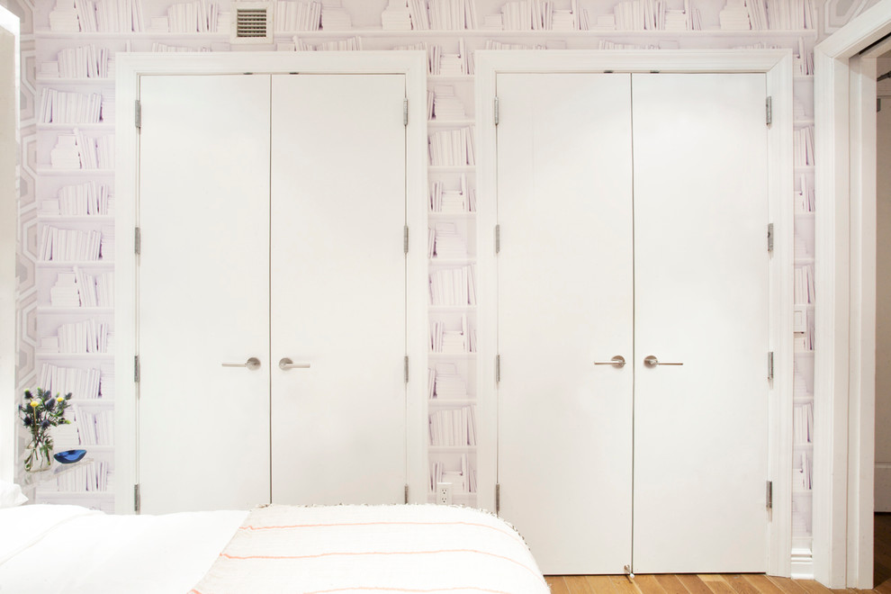 Contemporary bedroom in New York with medium hardwood flooring.
