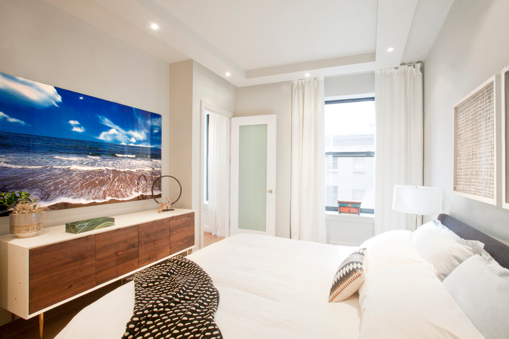Ejemplo de dormitorio actual con paredes beige y suelo de madera en tonos medios