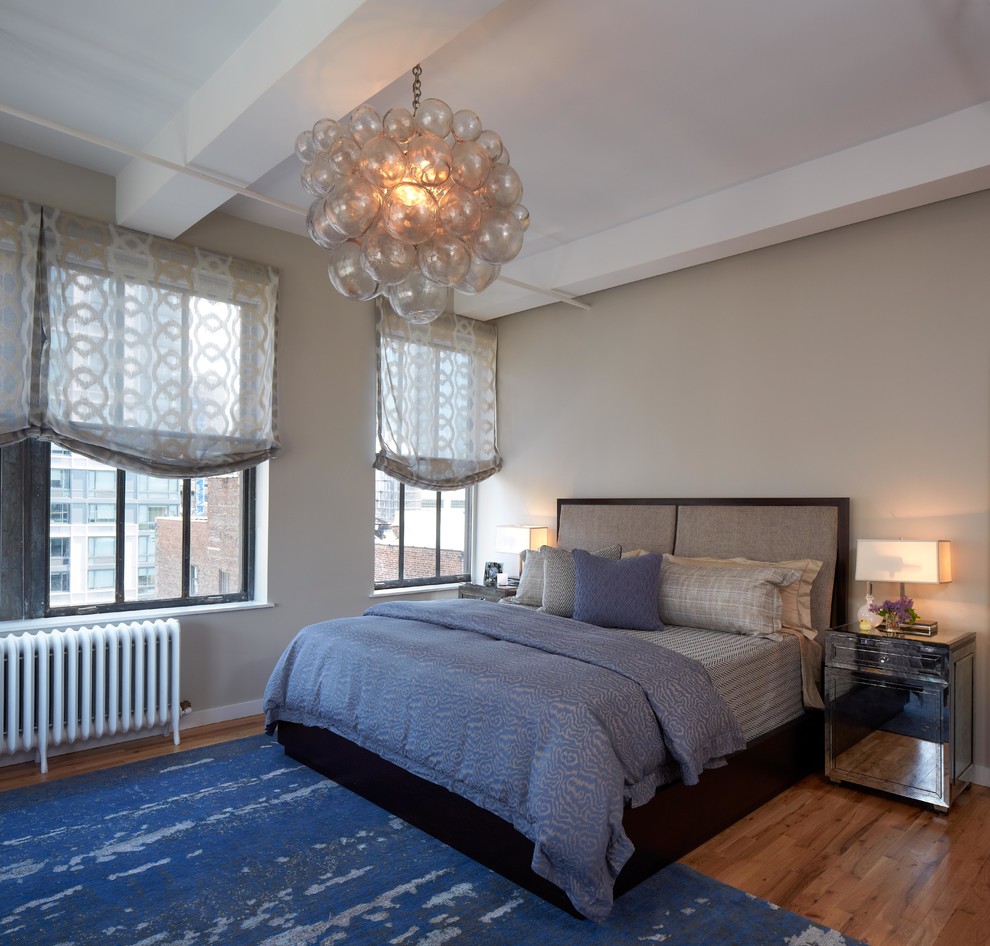 Immagine di una camera da letto contemporanea con pareti beige e pavimento in legno massello medio