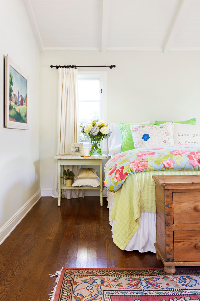 Cette photo montre une chambre parentale romantique de taille moyenne avec un mur bleu et un sol en bois brun.