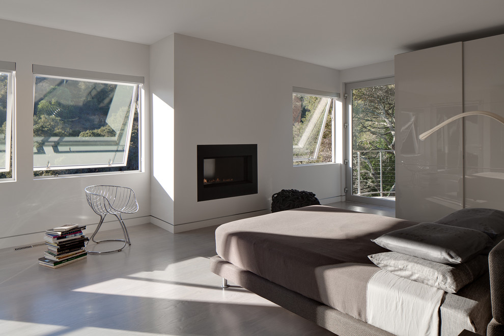 Example of a mid-sized trendy guest bedroom design in Los Angeles with white walls and a standard fireplace