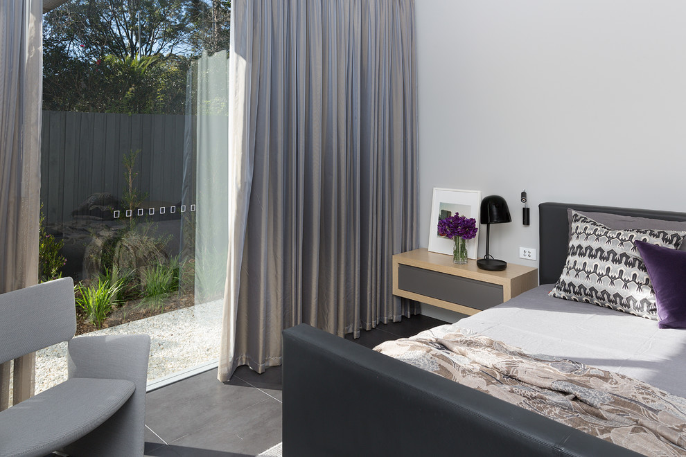 Minimalist master porcelain tile and gray floor bedroom photo in Sydney with gray walls