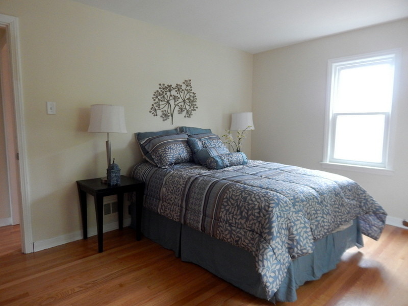 Modelo de dormitorio principal clásico renovado de tamaño medio sin chimenea con paredes beige, suelo de madera clara y suelo marrón