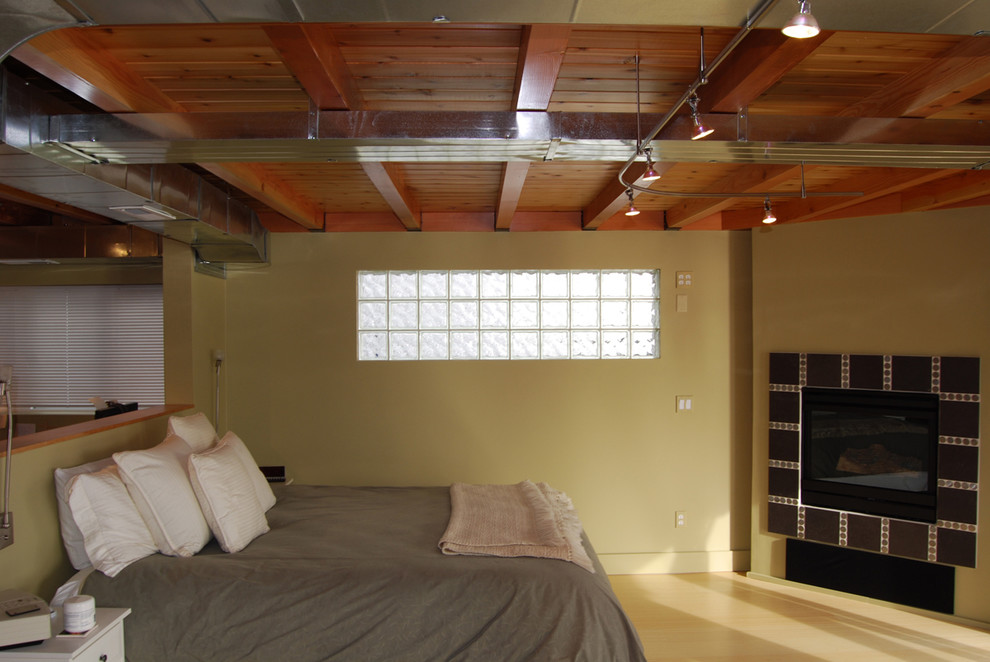 На фото: хозяйская спальня среднего размера в современном стиле с угловым камином и фасадом камина из плитки с