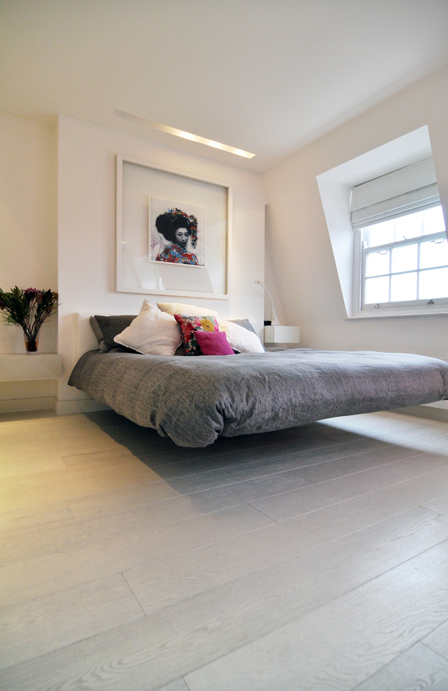 Design ideas for a contemporary grey and pink bedroom in London with white walls.