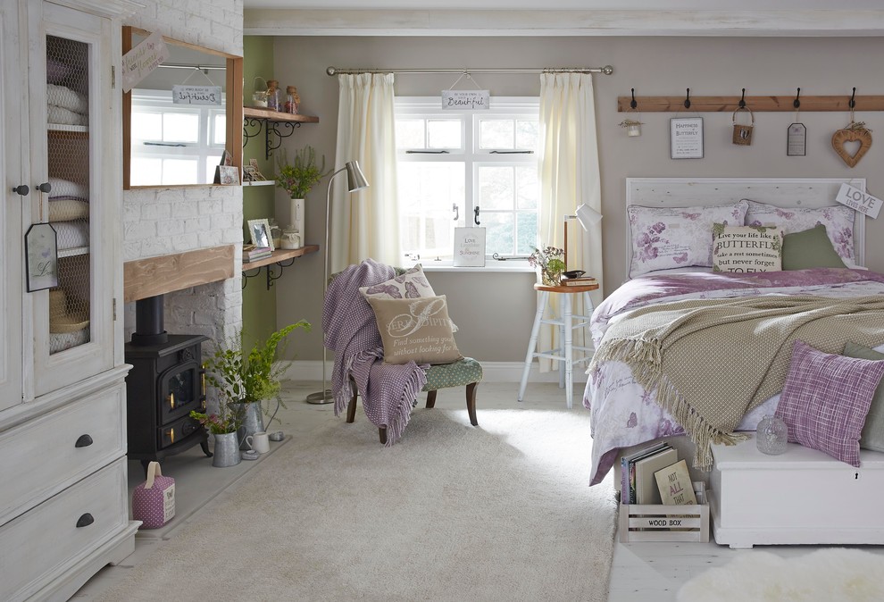 Foto de dormitorio principal clásico de tamaño medio con paredes verdes, suelo de madera clara, estufa de leña y marco de chimenea de ladrillo