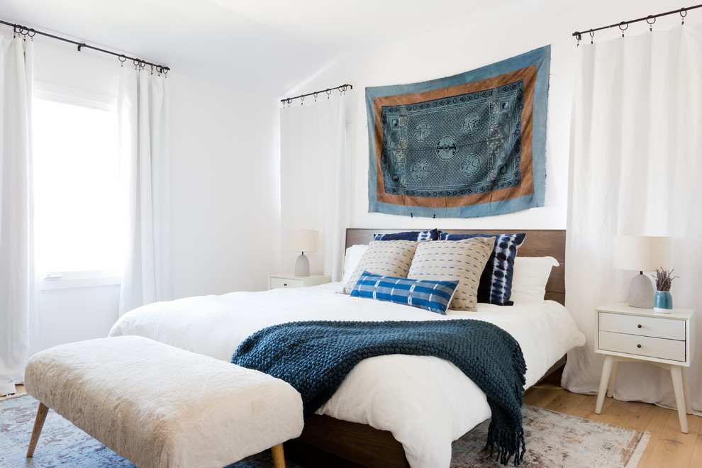 Esempio di un'In mansarda camera da letto design con pareti bianche e parquet chiaro