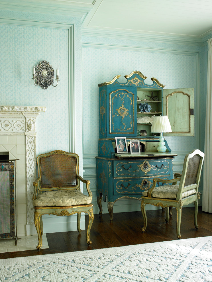 Ejemplo de habitación de invitados mediterránea grande con paredes azules, moqueta, todas las chimeneas y marco de chimenea de piedra