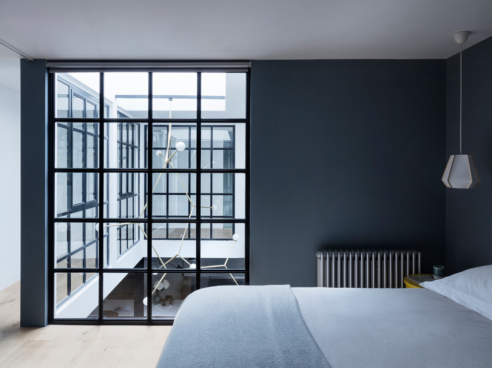 Ispirazione per una camera da letto industriale di medie dimensioni con parquet chiaro