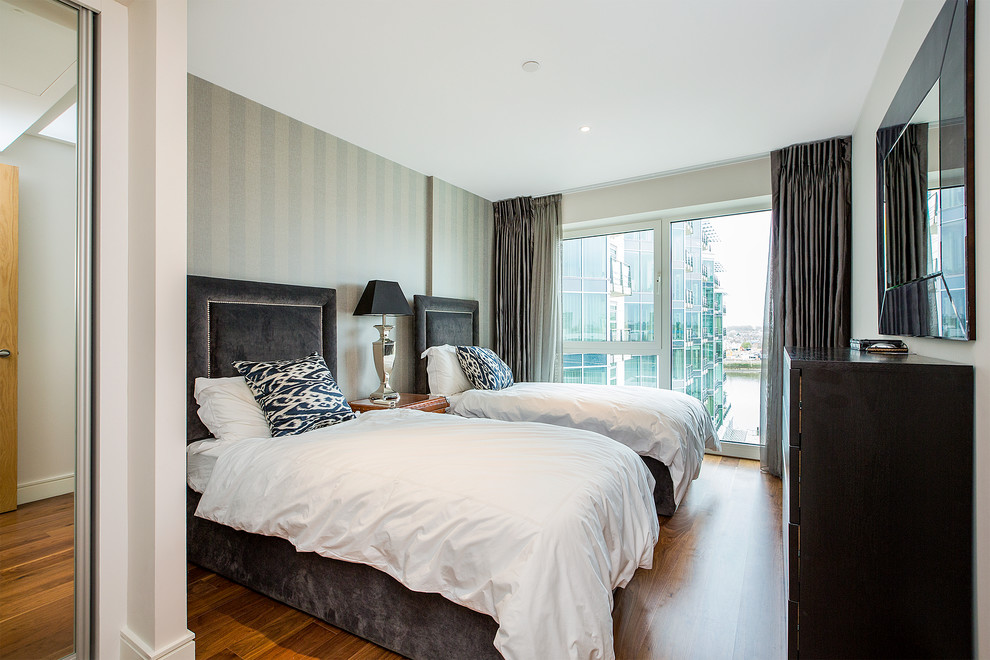 Diseño de habitación de invitados clásica renovada con paredes grises y suelo de madera en tonos medios