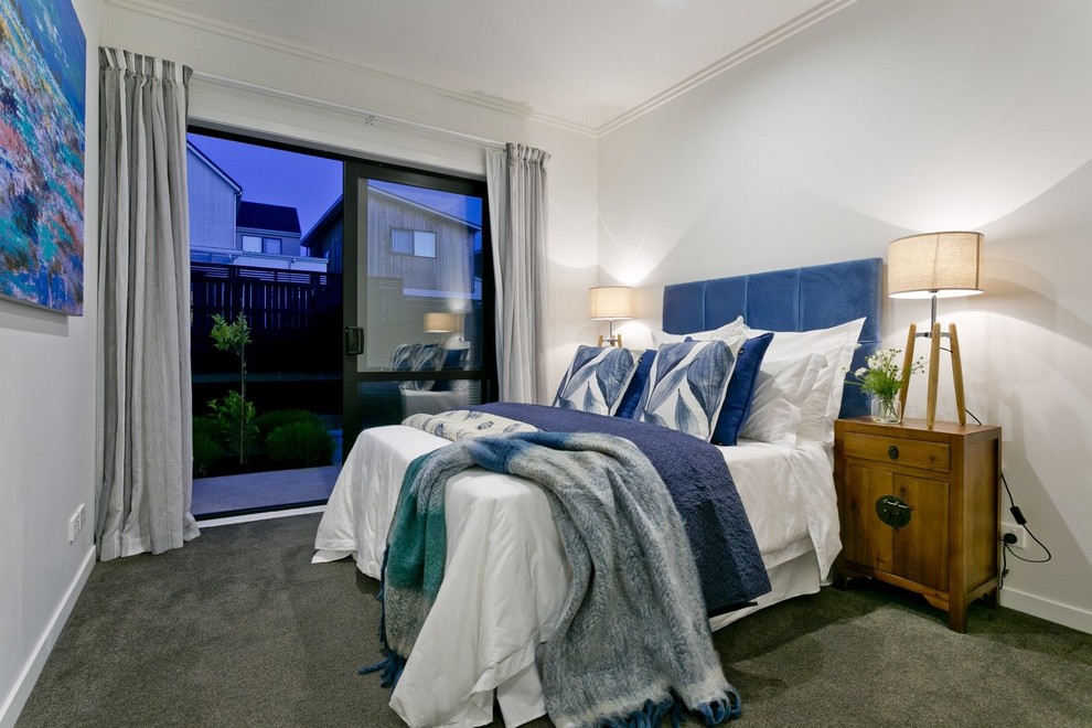 オークランドにあるトランジショナルスタイルのおしゃれな寝室 (白い壁、カーペット敷き、緑の床)