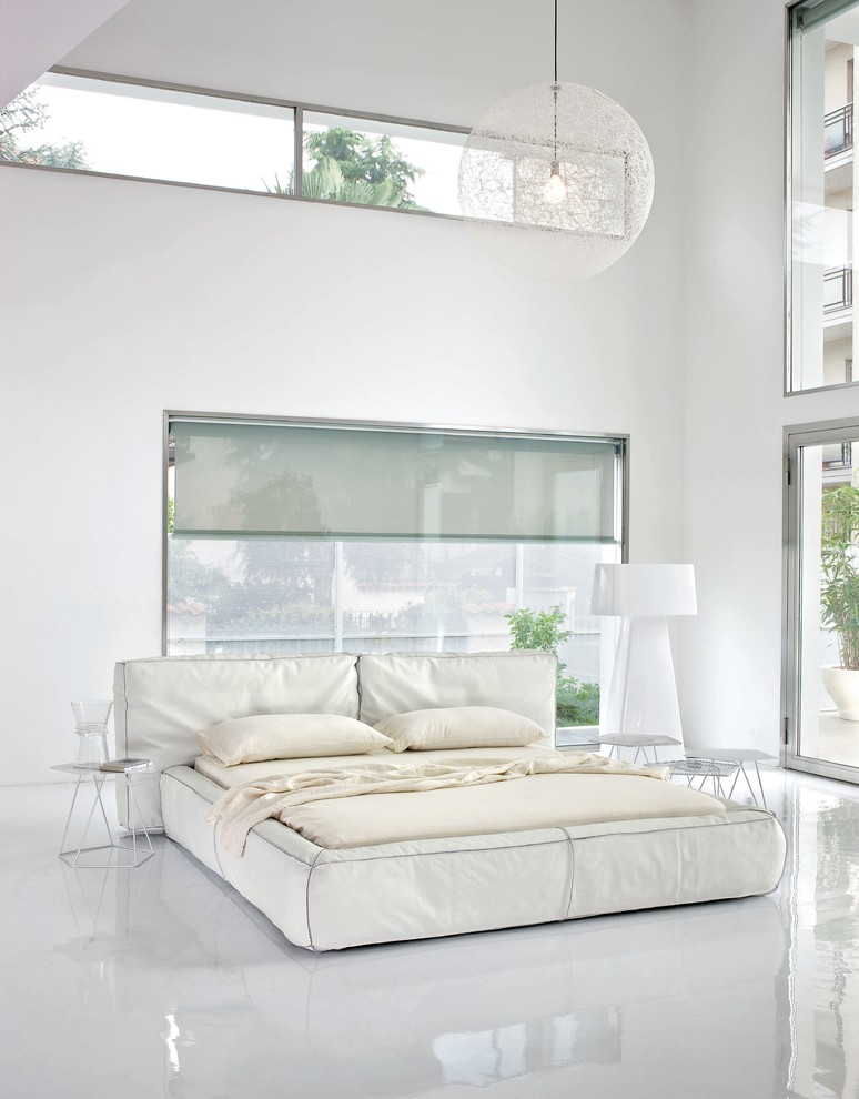 На фото: большая хозяйская спальня в стиле модернизм с белыми стенами, полом из винила и белым полом с