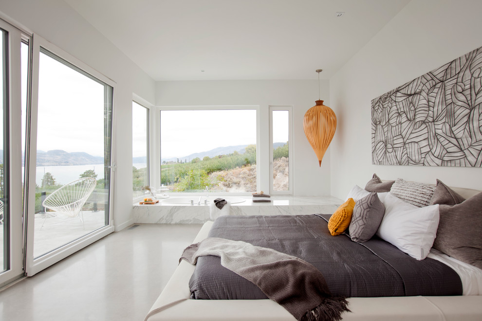 Großes Modernes Hauptschlafzimmer ohne Kamin mit weißer Wandfarbe und Betonboden in Vancouver