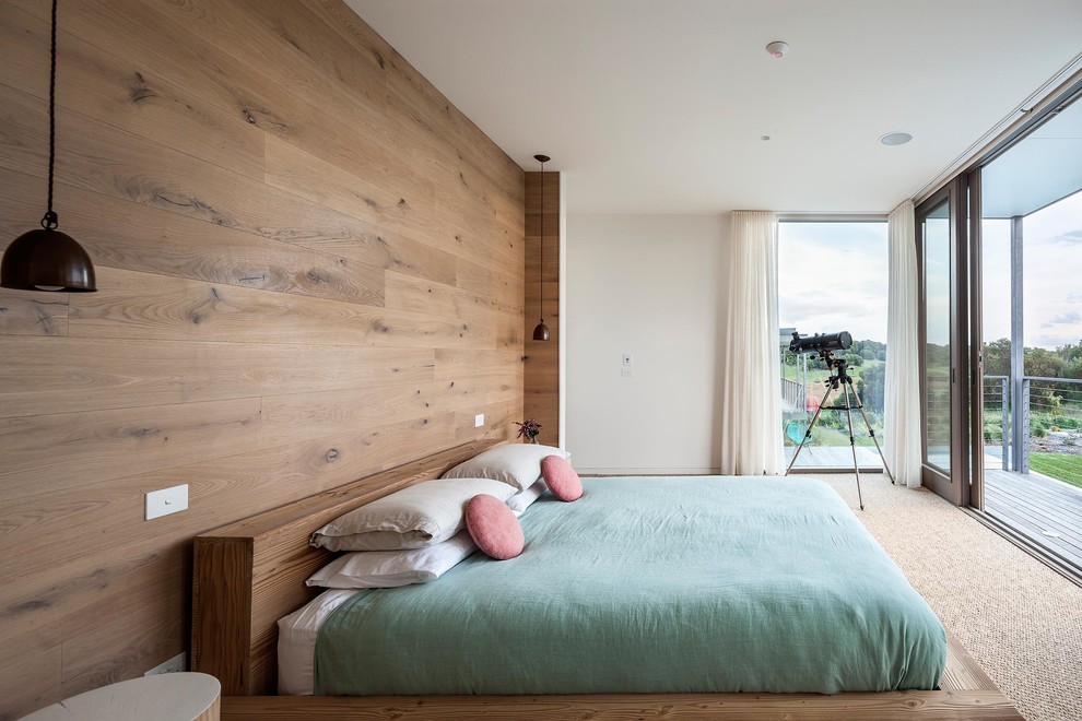 На фото: хозяйская спальня в скандинавском стиле с ковровым покрытием и коричневыми стенами с