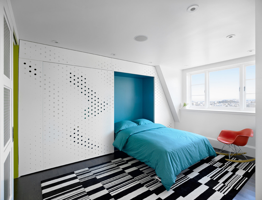 Cette image montre une chambre minimaliste avec un mur bleu et parquet foncé.