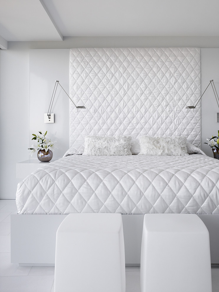Modern inredning av ett litet sovrum, med vita väggar och marmorgolv