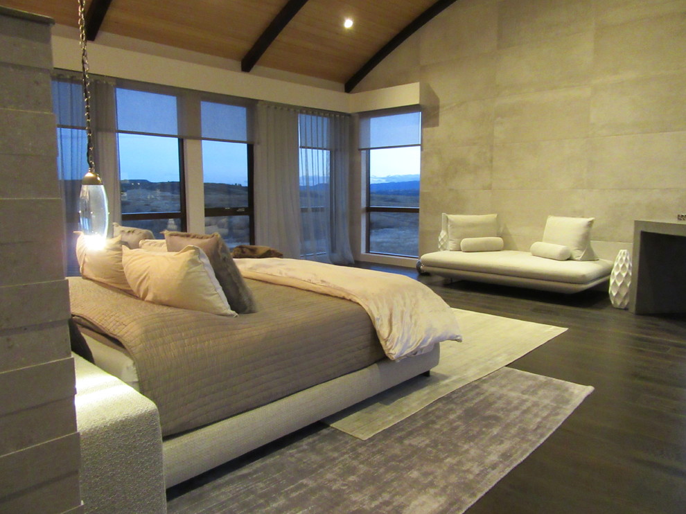 Exemple d'une très grande chambre parentale tendance avec un mur gris, parquet foncé et un sol marron.