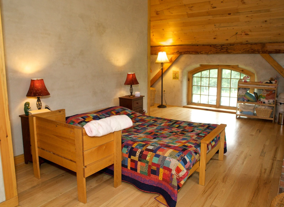 Modelo de dormitorio principal tradicional grande con paredes grises y suelo de madera clara