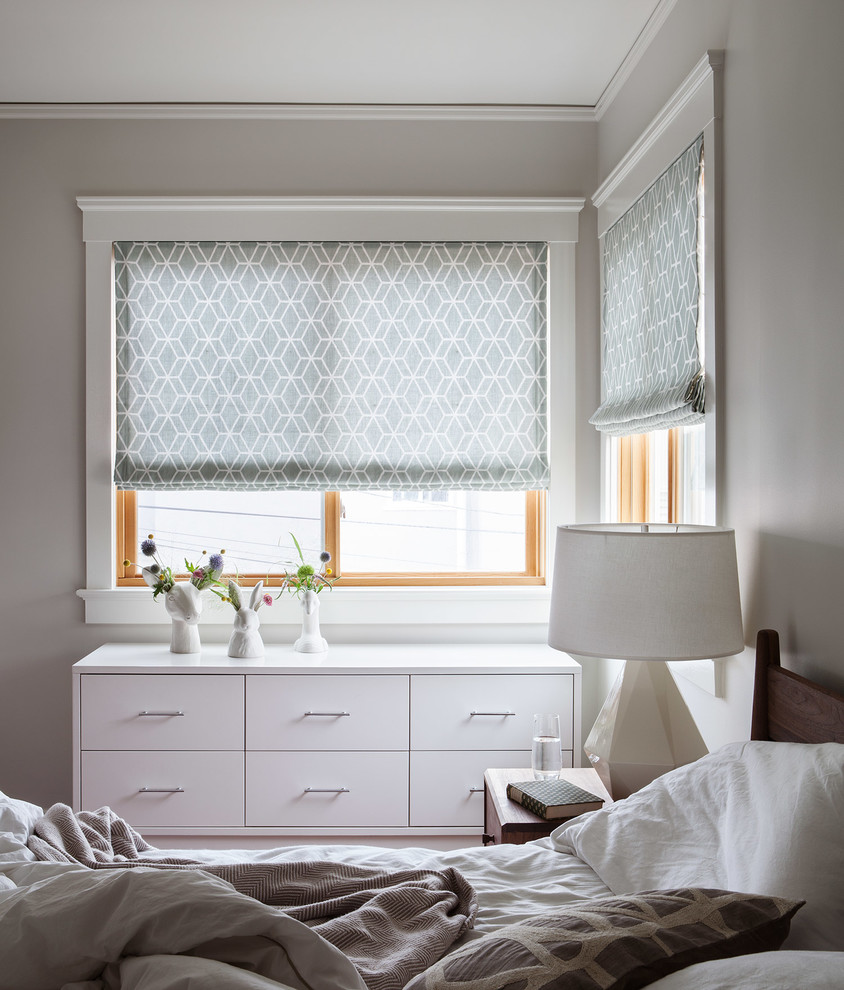 Imagen de dormitorio principal actual de tamaño medio sin chimenea con paredes grises y suelo de madera en tonos medios