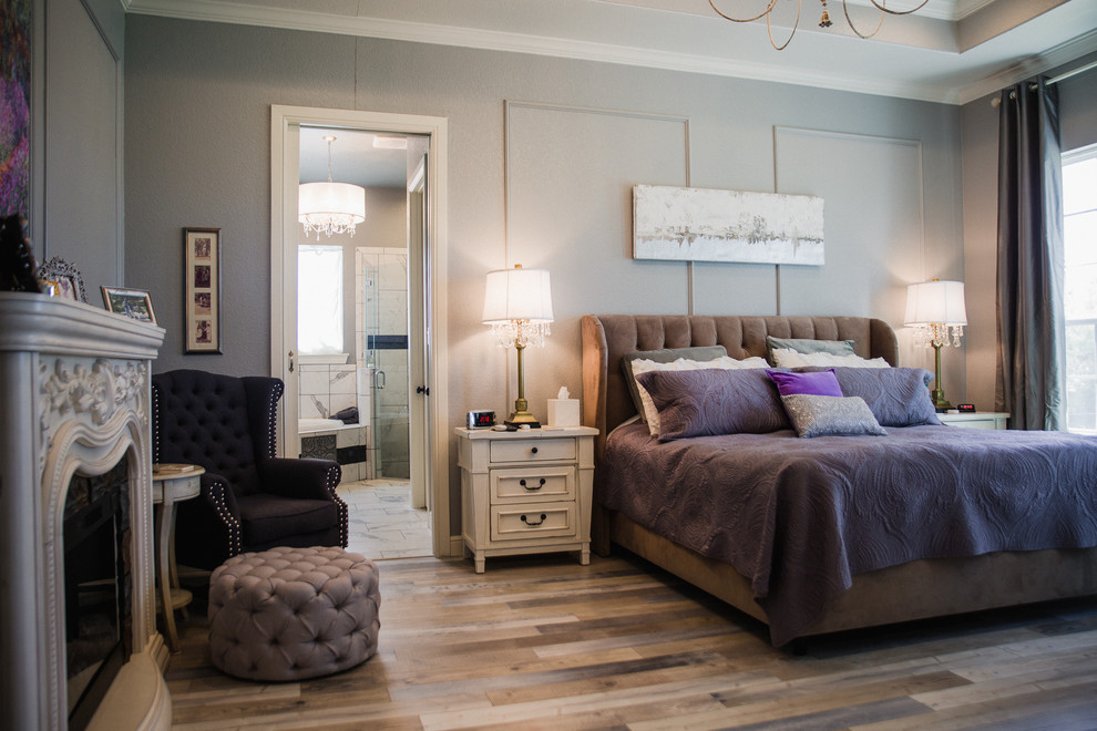 Стильный дизайн: хозяйская спальня среднего размера в классическом стиле с серыми стенами, темным паркетным полом, стандартным камином, коричневым полом и фасадом камина из плитки - последний тренд