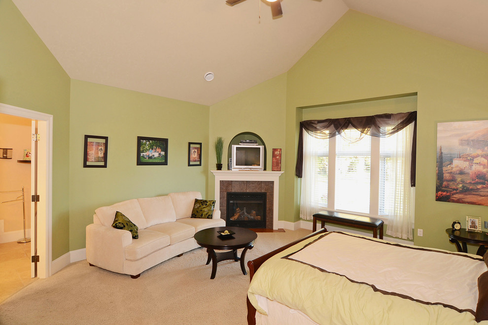 Идея дизайна: хозяйская спальня среднего размера в стиле кантри с зелеными стенами, ковровым покрытием, угловым камином и фасадом камина из плитки