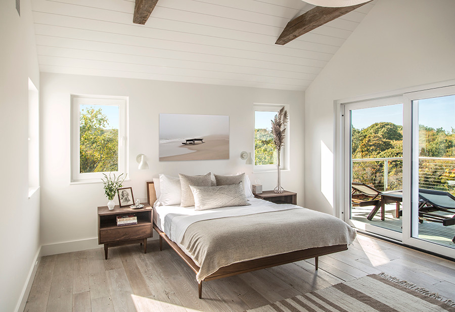 Kleines Modernes Gästezimmer mit weißer Wandfarbe, hellem Holzboden, Eckkamin und Kaminumrandung aus Metall in New York