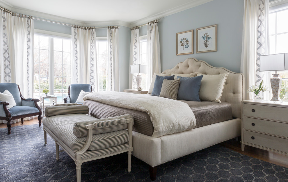Elegant master medium tone wood floor and brown floor bedroom photo in Dallas with blue walls