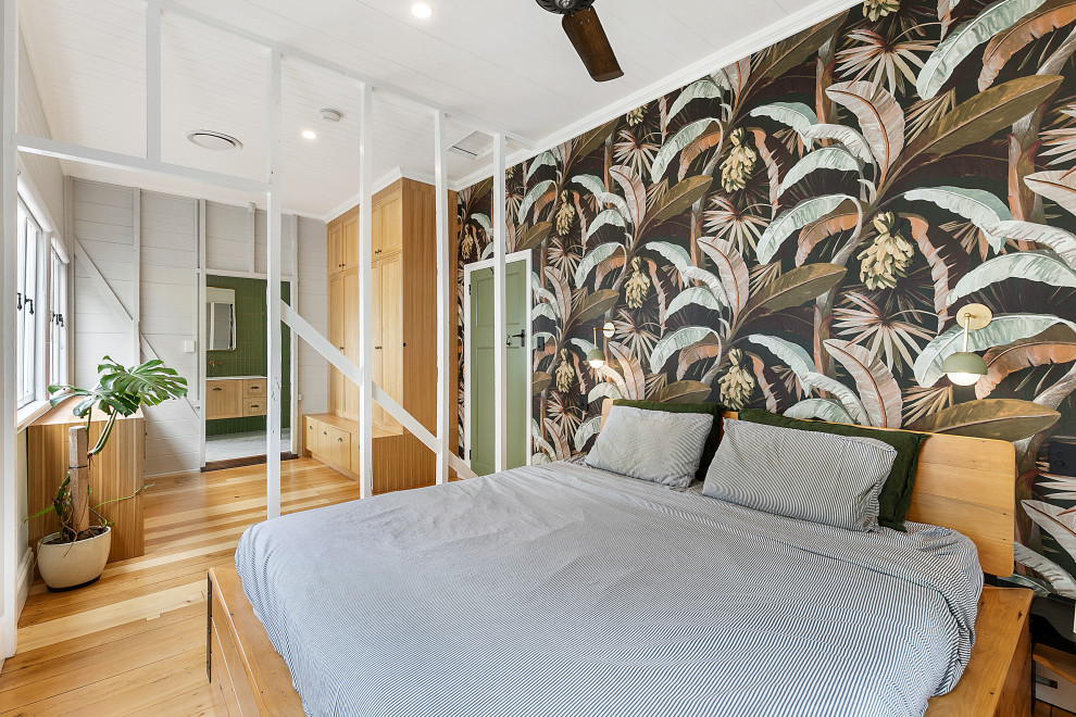 This is an example of a medium sized modern master bedroom in Brisbane with white walls and light hardwood flooring.