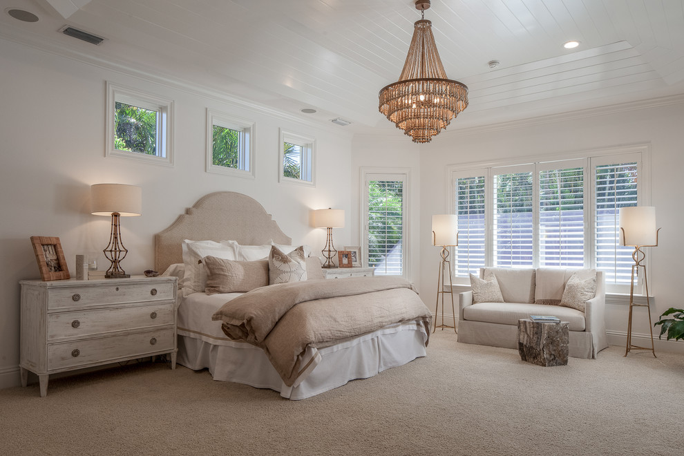 Inspiration for a tropical master carpeted and beige floor bedroom remodel in Miami with white walls