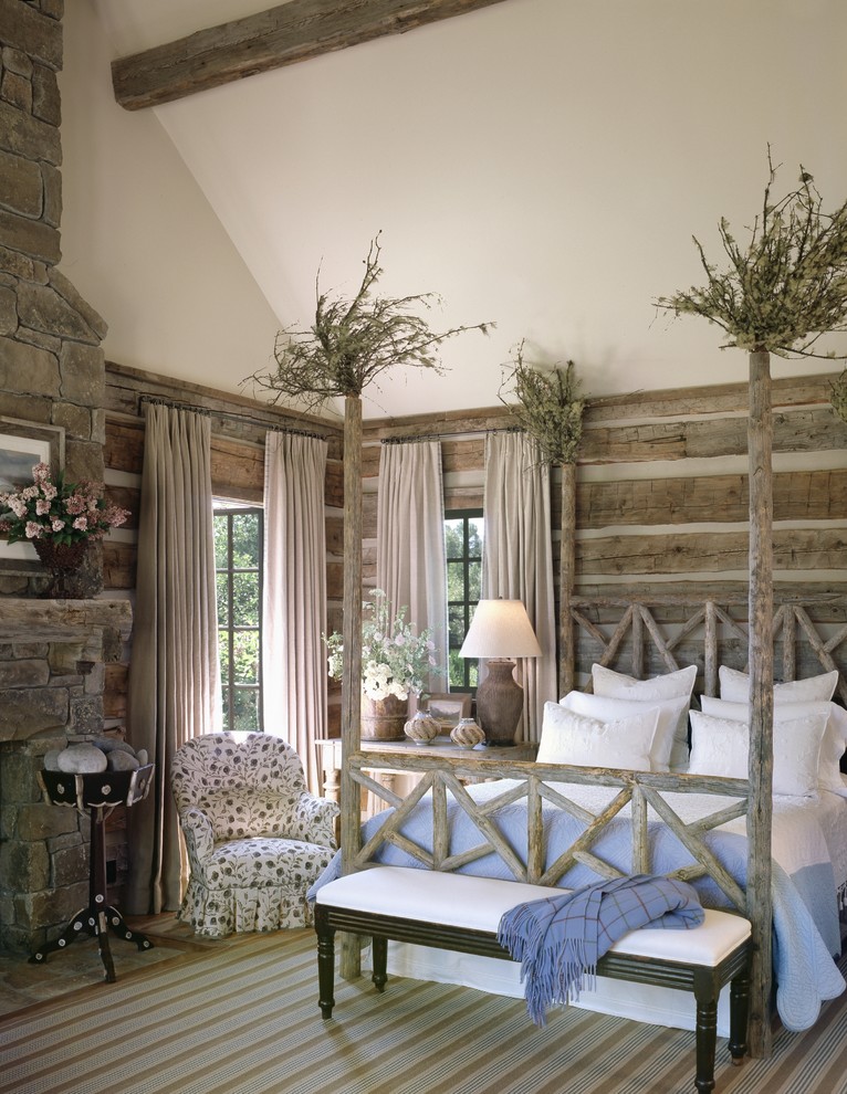 Classic bedroom in Other with a stone fireplace surround.