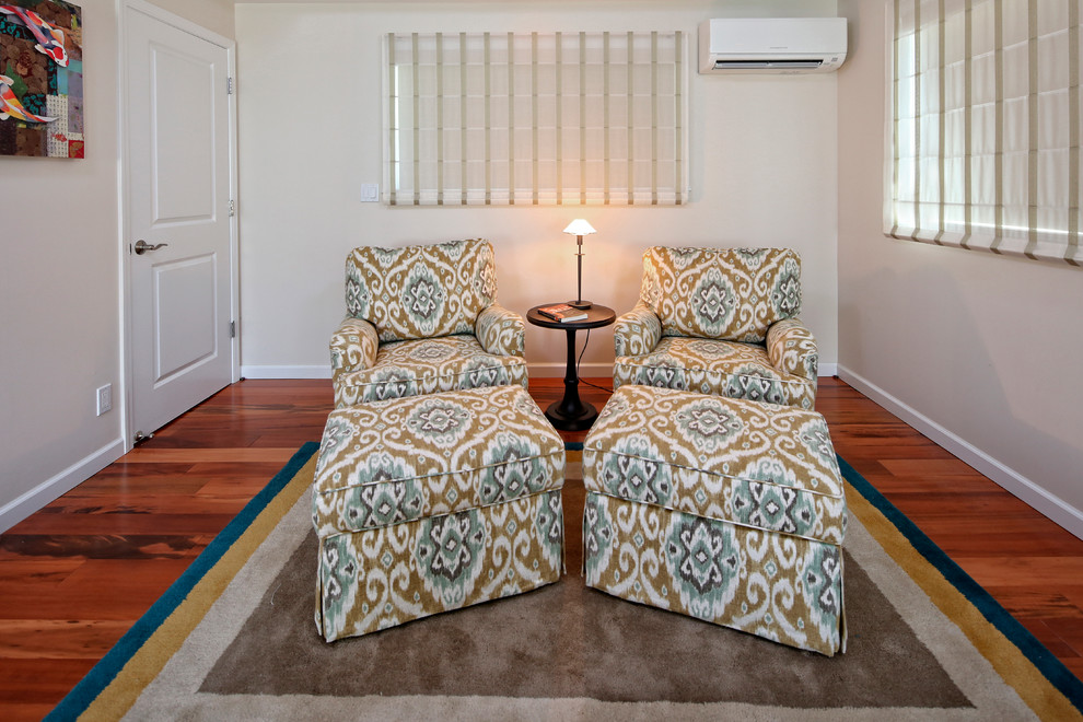 Foto di una camera matrimoniale tropicale con pareti beige e pavimento in legno massello medio